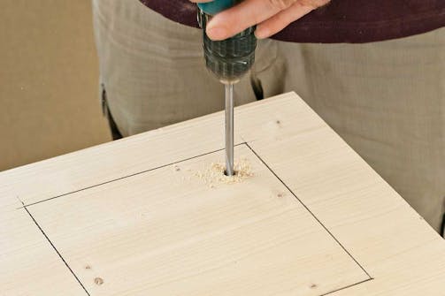 Så här sågar du en fyrkant med sticksåg: Börja med att markera fyrkanten och borra sedan ett hål ett par centimeter innanför strecket. Så här sågar du en fyrkant med sticksåg: Börja med att markera fyrkanten och borra sedan ett hål ett par centimeter innanför strecket.